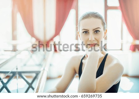 Ballerina portrait in bright ballet studio. Toned image.