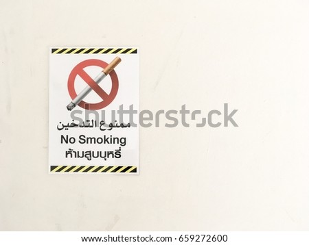 No smoking sign on the wall with Thai and Arab languages Spelling. English Translate; No Smoking.