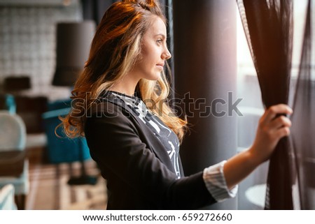 Stunning blonde looking through window