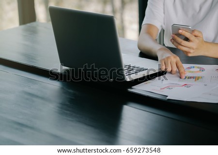 Business man hands working on computer with phone, paper and notebook on office desk table .View from above.Business analysis and strategy concept