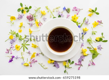 Cup of black coffee on the background of small flowers and leaves. Cute simple background. Floral backdrop for banners, cards, covers. The theme of the beginning of the day, summer, spring.