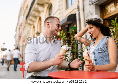 Portrait of a smiling couple eating ice cream and having fun in the city