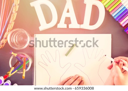 Step by step. Little girl tracing her hands for Father's Day card.
