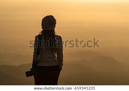 Silhouette of photographer taking picture of landscape during sunset, soft and select focus 