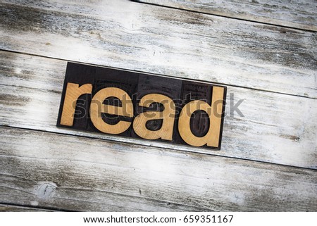 The word "read" written in wooden letterpress type on a white washed old wooden boards background.