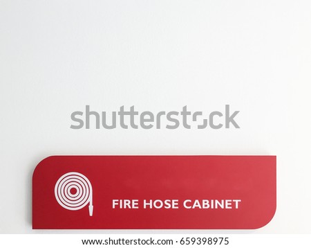 Fire hose cabinet label on the white wall of the new building, Copy space.