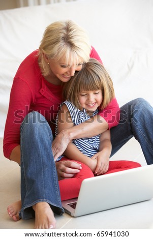 Middle age woman with young girl using laptop computer