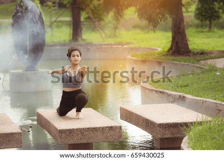 Young woman practicing yoga On the waterfront concrete floor.