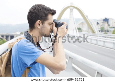 young man with the camera taking pictures in the city