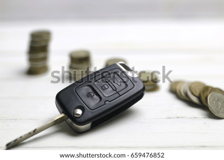 car key and coin on background