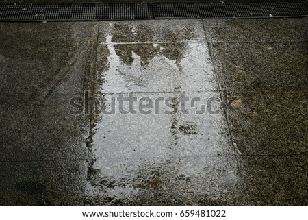 Shadows of people reflected in a rainy floor
