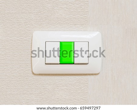 Light switch on green background, free copy space. Saving concept.