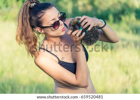 The girl is holding a hedgehog