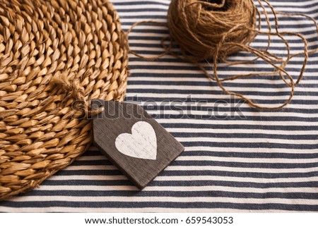 Handmade wooden house like symbol of sweet home and  rustic rope on striped fabric. Home sweet home.Space for text.