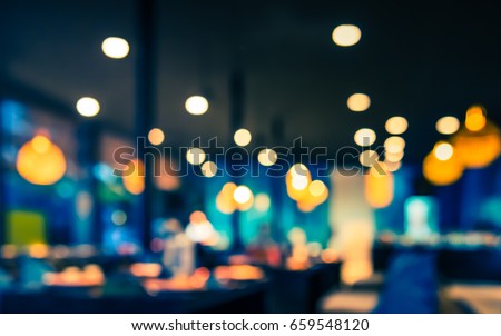 Abstract blur image of Cafe or  restaurant in night  time with bokeh for background usage .(vintage tone)