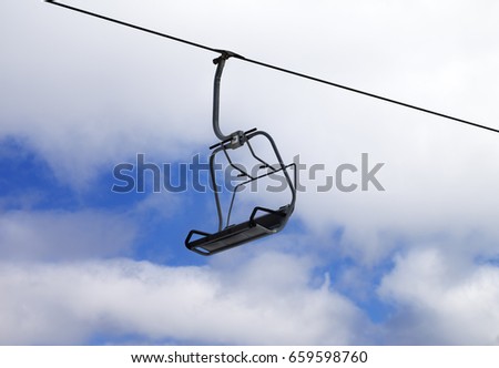 Chair-lift and cloudy sky at winter day on ski resort
