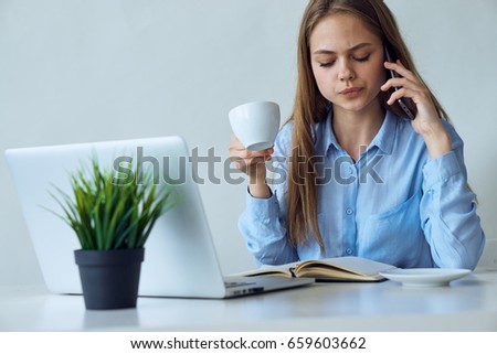 Business woman holding a mug, a woman talking on the phone.