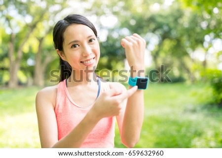 Young woman use of smart watch in park