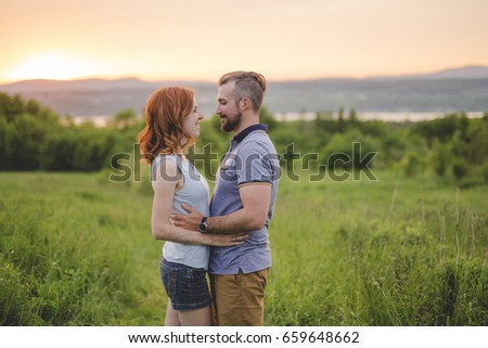 A Young couple enjoying the sunset in the meadow
