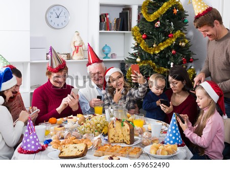Happy family members looking through photos during Christmas dinner