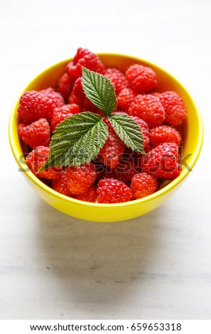Sweet raspberries in bowl on table. Close up, top view, high resolution product