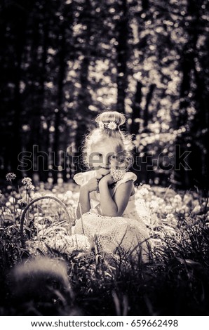adorable blond girl in spring forest with white blossoming flowers monochrome