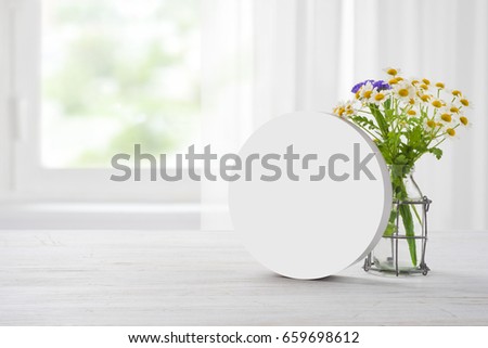 Clear plain banner stand and camomile bouquet on wooden table