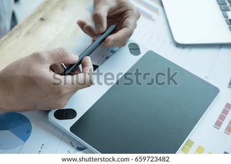 male graphic designer working with computer and color swatch. creative man using stylus pen and digital tablet at office. Architect using work tools and sample colour catalog. business, technology