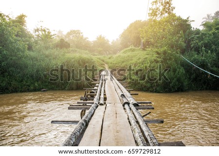 Wooden bridge crossing the river in Thailand.