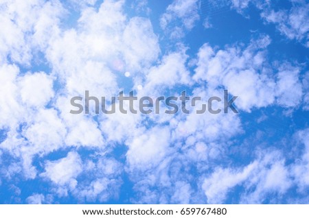 Blue sky background with clouds and sun.