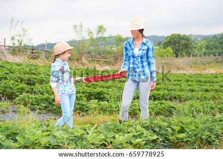 Mother and daughter in strawberry field