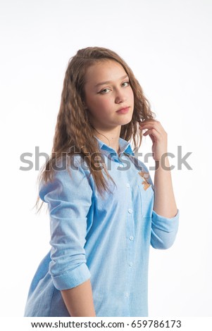 Portrait of a beautiful girl with long hair in a blue shirt on a white background