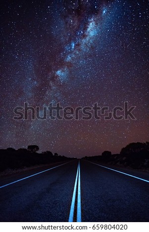 The Milky Way stretches across the night sky over an open road. Western Australia, Australia.