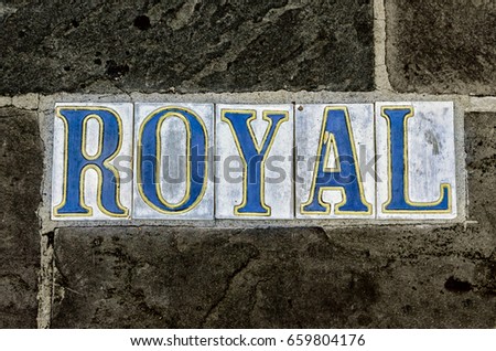 Royal Street, French Quarter, New Orleans, LA. Street tiles with white background and blue lettering on public sidewalk. 