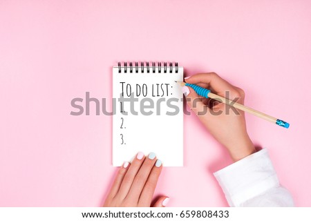 To do list in spiral notepad. Trendy pink background, flat lay style. Royalty-Free Stock Photo #659808433