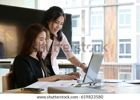 Asian business people group present and review financial marketing strategy business plan in meeting room together. Kindly supervisor train new staff in office.  Royalty-Free Stock Photo #659823580