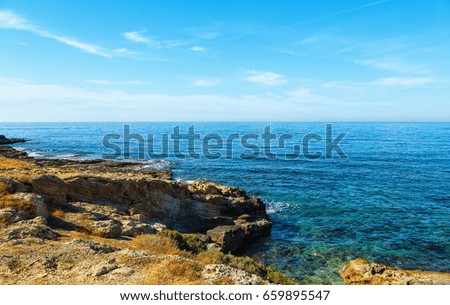 Volcanic rock on shore of the island of Crete Greece, cloud sun weather