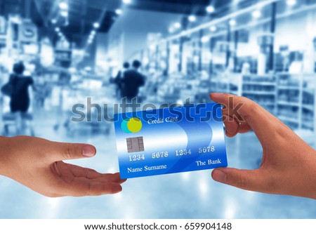 Hand holding credit card on super market blur background, online payment, electronic commerce financial concept  