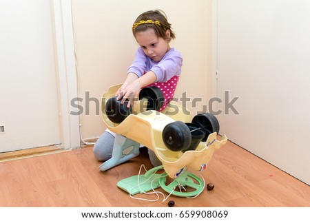 Cut little girl fixing toy car
