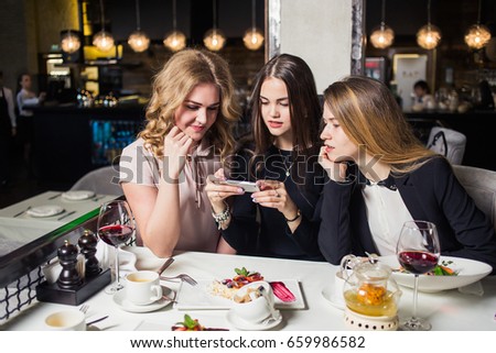 friends using smartphones to take photos of their food.