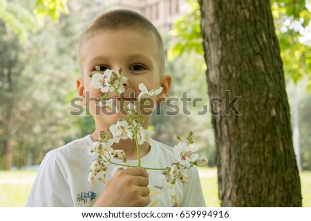 Little boy smelling flowers