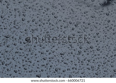 Raindrops on the side of a black car