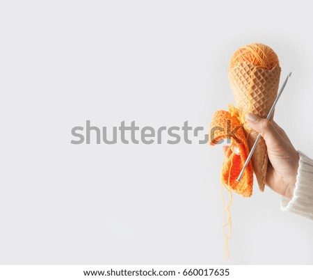 Balls of yarn lie in a waffle cone for ice cream. Coloured wool.