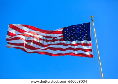 american flag waving in blue sky