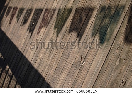 Photograph of Shadows of Colorful Banners on a Wooden Boardwalk