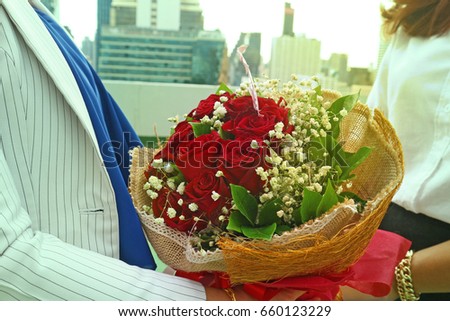 Women hold flower bouquet