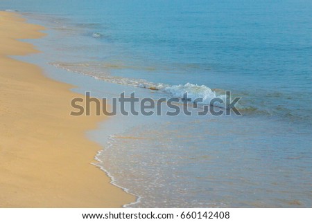 wave of blue ocean on sandy beach.