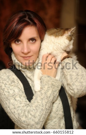 Young woman with a cat in her arms