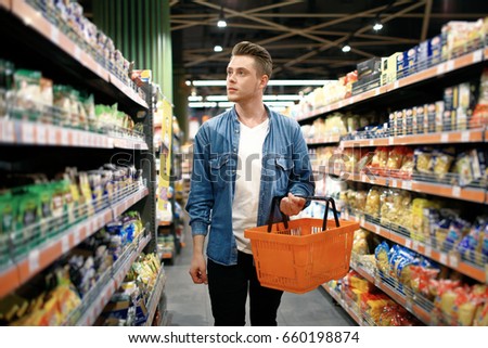 a young man chooses foods at the supermarket
