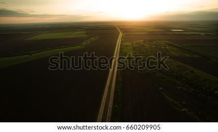 Track outside the city at sunset from a height.